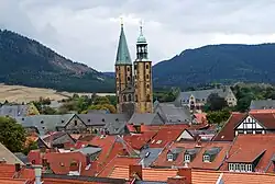 A view at a town with houses with red roofs and a church with two bell towers