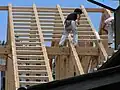 A steeply pitched, timber framed roof under construction in Japan