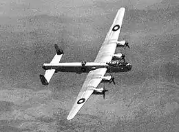 Four-engined military aircraft with twin tail fins in flight