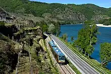 Train running through river valley