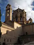 Entrance to a beige stone church decorated with sculptures..