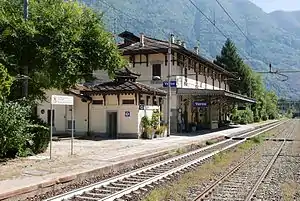 Two-story building with hip roof next to double-track railway line