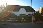 Thatched house with two mock-chimney gables to street. Some 2 × 2 sashes with louvred shutters, modernised enclosed stoep with 4 × 4 door. Very dilapidated. Type of site: House Current use: House.