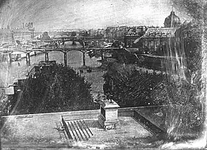 Daguerreotype of the Pont Neuf, 1836-39. Two people can be seen lying in the shade of the statue. Said to be the first successful daguerreotype taken in open air by Daguerre and Mathurin Fordos.