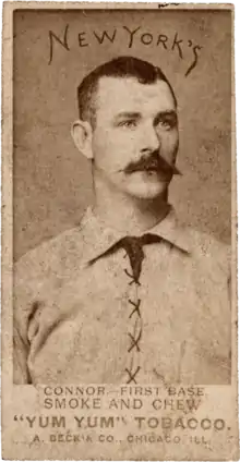 A mustachioed man with parted dark hair