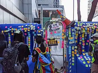 Post-it stickers on the water barricades set up by the police.