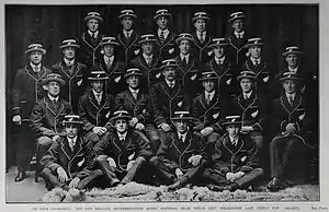 A team of men wearing blazers and hats posing for a formal photo.