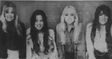 Black and white photo of four women standing in a row