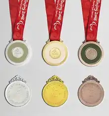 Six medals are shown to display the front and back of each. From left to right, silver, gold and bronze.