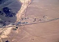 Aerial view of Baker looking north: I-15 jogs south around the town, leaving Baker Boulevard, the main street, to show where the pre-interstate highway (US 91 and US 466) went. Baker Airport sits just north of the city alongside northbound CA 127, the "Death Valley Road".
View of Baker from the east on I-15