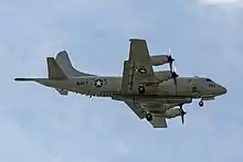 Side-view of a four-engine propeller aircraft in landing configuration.