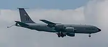 Large, 4-engine aircraft in flight with components for aerial refueling