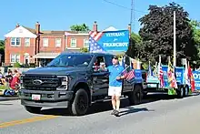 Supporters walk alongside a "Veterans for Franchot" truck in the July 4 parade in Dundalk, Maryland