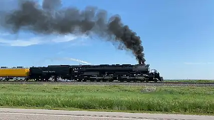 An articulated steam locomotive pulling a passenger train