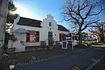 Single storey, thatched, saddle roof, 3 bay Cape Dutch house with straight end gables. On the left are a chimney and loft door with ladder. The front gable has four pilasters, a 3-lobed pediment and a 6 pane casement window. 12 x 12 sashes with shutters. Type of site: House Current use: House.