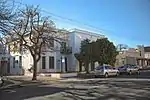 Double storey, parapeted building with string course, partly set back, with rustication and corner quoins. 3 bay section has French doors with louvred shutters to the ground floor and 2 × 2 sashes to the first floor. 2 bay, set back section has 4 panel d Type of site: Commercial Current use: Offices.