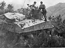 Sherman tank on the crest of a hill.