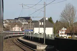 Two-story building with gabled roof next to side platform