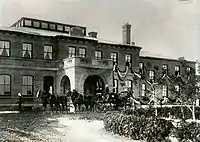  A sepia photograph of the Government House during the Royal Visit. A horse-drawn carriage is in front of the building.