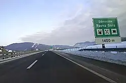 Motorway approaching the Ravna Gora rest area; a directional traffic sign specifying some rest area amenities is visible on the right side of the road.