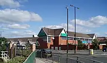 A 1980s medium-sized supermarket building, viewed from across the Great North Road