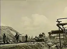 Infantrymen advance alongside tanks