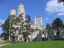 Roofless stone ruins on a grass lawn