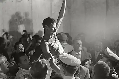 Abebe lifted above a crowd in celebration