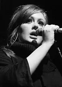 A young woman singing into a microphone