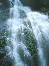 A waterfall cascading down several small ridges splitting one large fall into several smaller ones