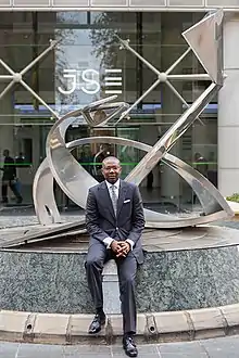 Aigboje Aig-Imoukhuede sitting in front of JSE Building