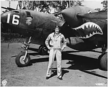 Man standing in front of a twin-propeller aircraft