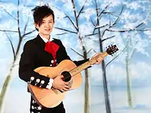 Picture of Akio Hong, an Asian man, holding a guitar.