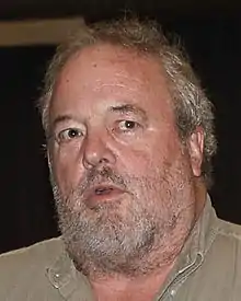 A close up photo of a bearded man.