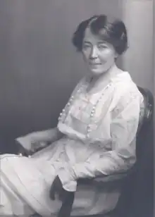 Black and white photograph of a seated woman in a white Victorian-style dress