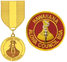 the badge is a round red patch with a gold border; the outer edge has the text Hawaiiana and Aloha Council; the inner circle has the image of a poi pounding stone with a flaming torch in front; the medal uses the same image as the badge suspended from a red and gold ribbon