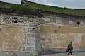 A man walks past an earthen wall in Xizhou.