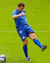 Heavily-built white man in football clothing, apparently training.