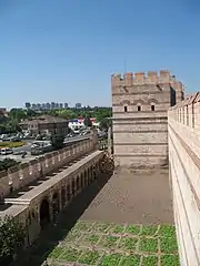 Photograph showing a stone bastion in the front, with a wall to the left and right and a space in between