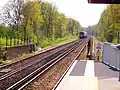 A train heads south from Ash Vale station towards Aldershot.