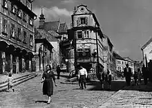 building along a street, with a church in the background