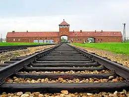 Entrance gate in red brick and railway tracks