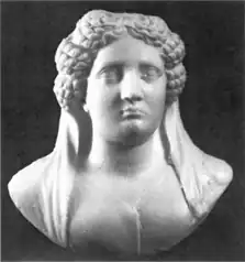 Black and white image of the face and upper torso of a sculpted woman