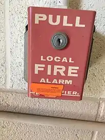  A Notifier pull station at Oklahoma State University.  The orange sticker on it warns would-be pranksters of the consequences of false alarms.