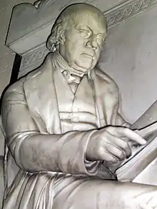 Marble statue of a man reading a book