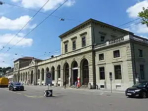 Wide two-story stone building with two three-story towers