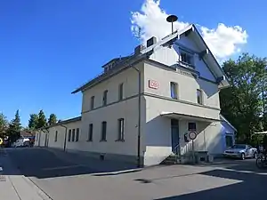 Three-story stucco building next to railway line