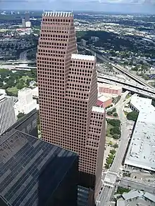 Large building with three, segmented tower setbacks, each with  a steeply pitched roof line topped with a series of spires.