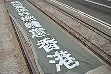 Someone spread out a large straight flag on the tramway off CNT Center in Wan Chai, saying "We really love Hong Kong."