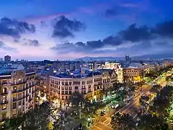 A chamfered building and street corner on Barcelona's Passeig de Gràcia. Here the building is chamfered but the sidewalk/street has taken on a conventional, 90-degree layout, eliminating the loading zone or parking spaces.